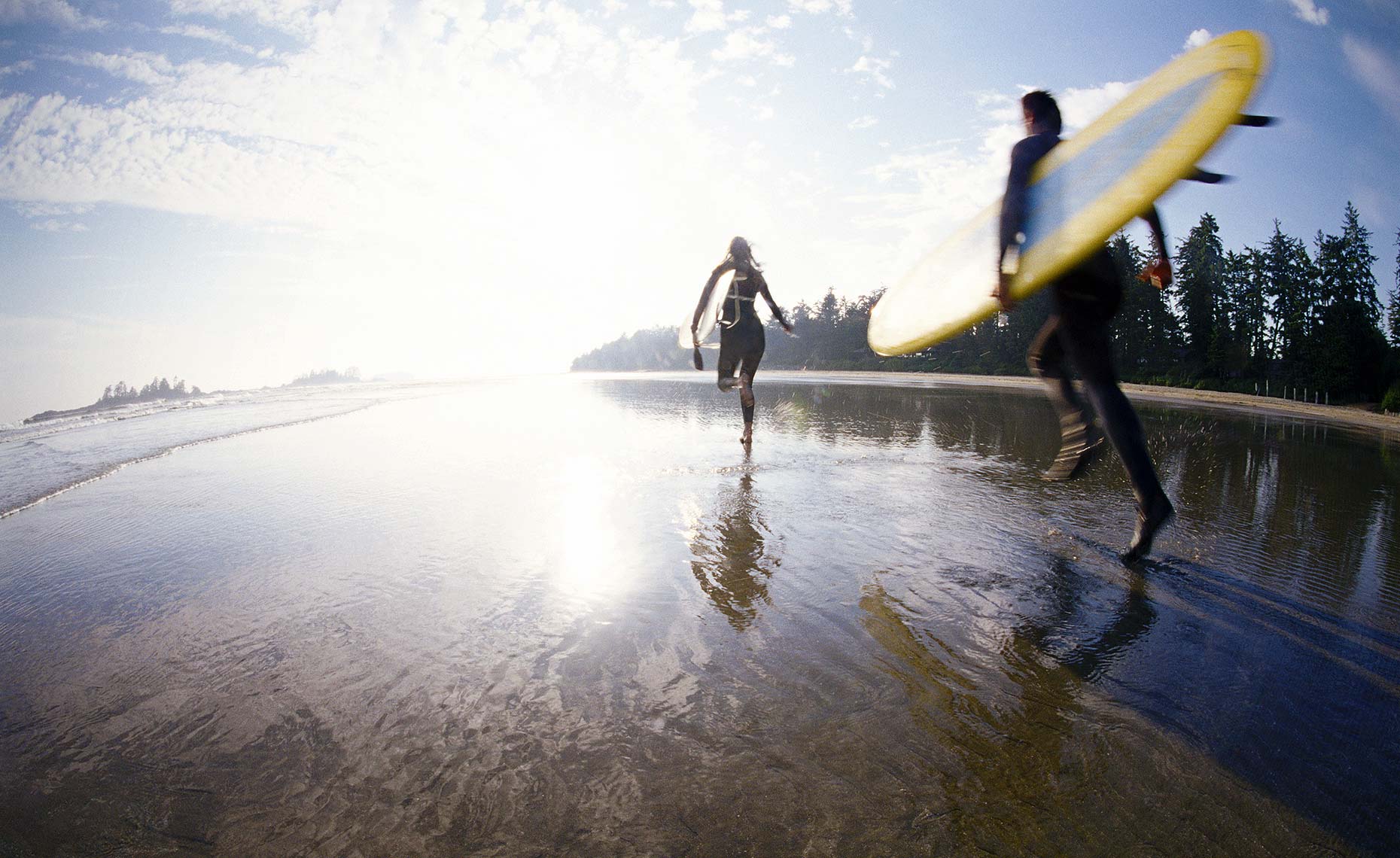 Tofino surfers running on beach